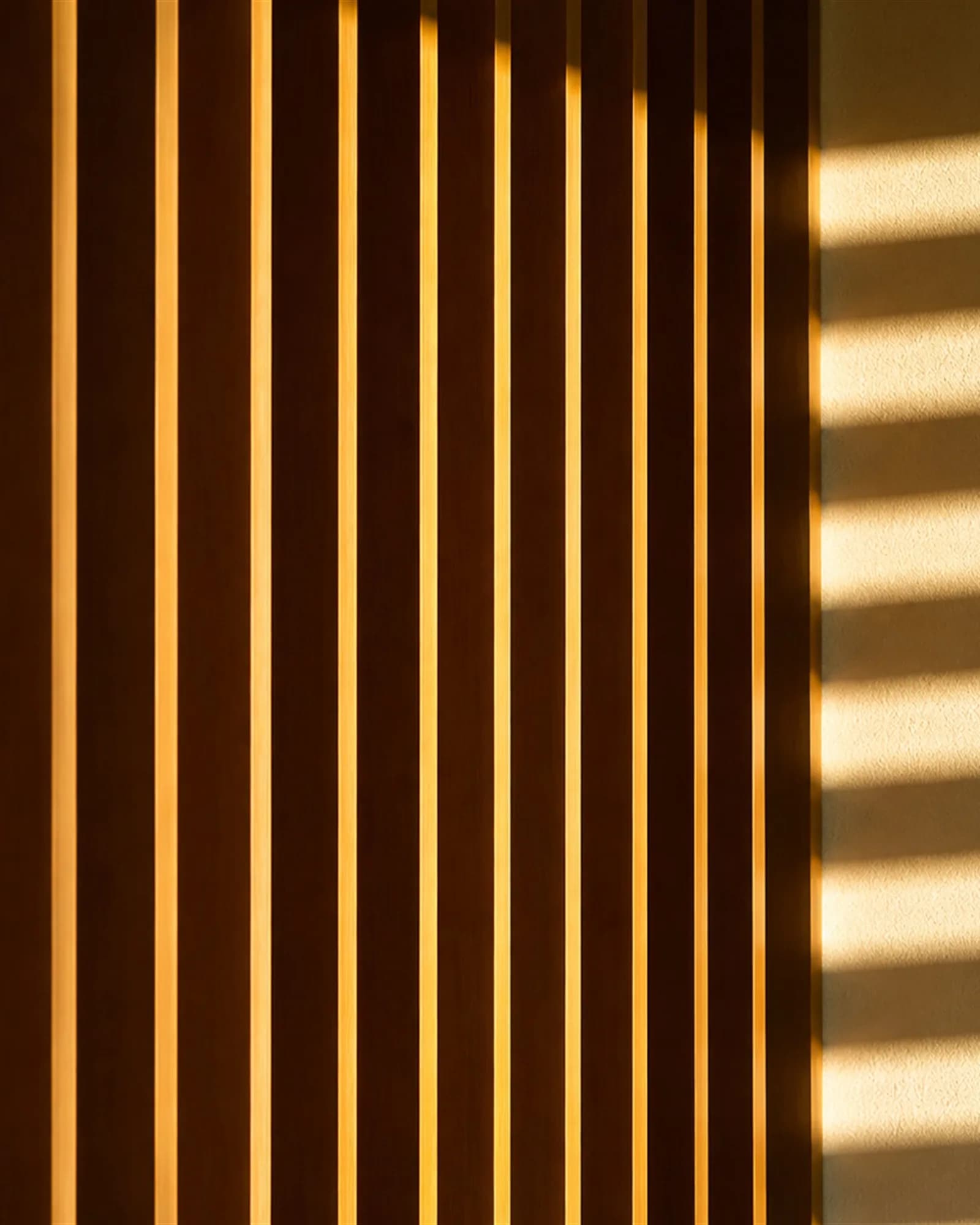 Low sun slicing between teak louvres, throwing a striped rhythm onto lime plaster