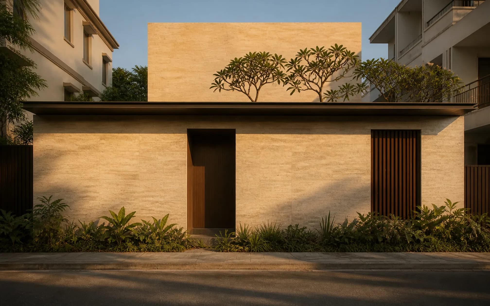 Street elevation — a near-solid plane of warm travertine with a single deep teak screen and recessed bronze entry