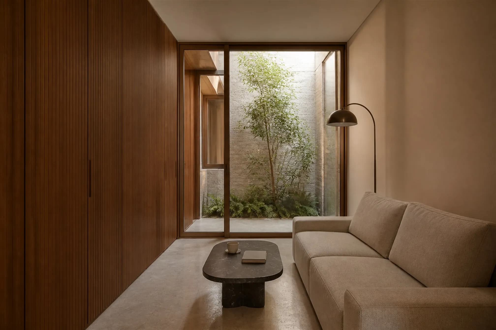 Compact living room with a full-height flush teak joinery wall concealing all storage